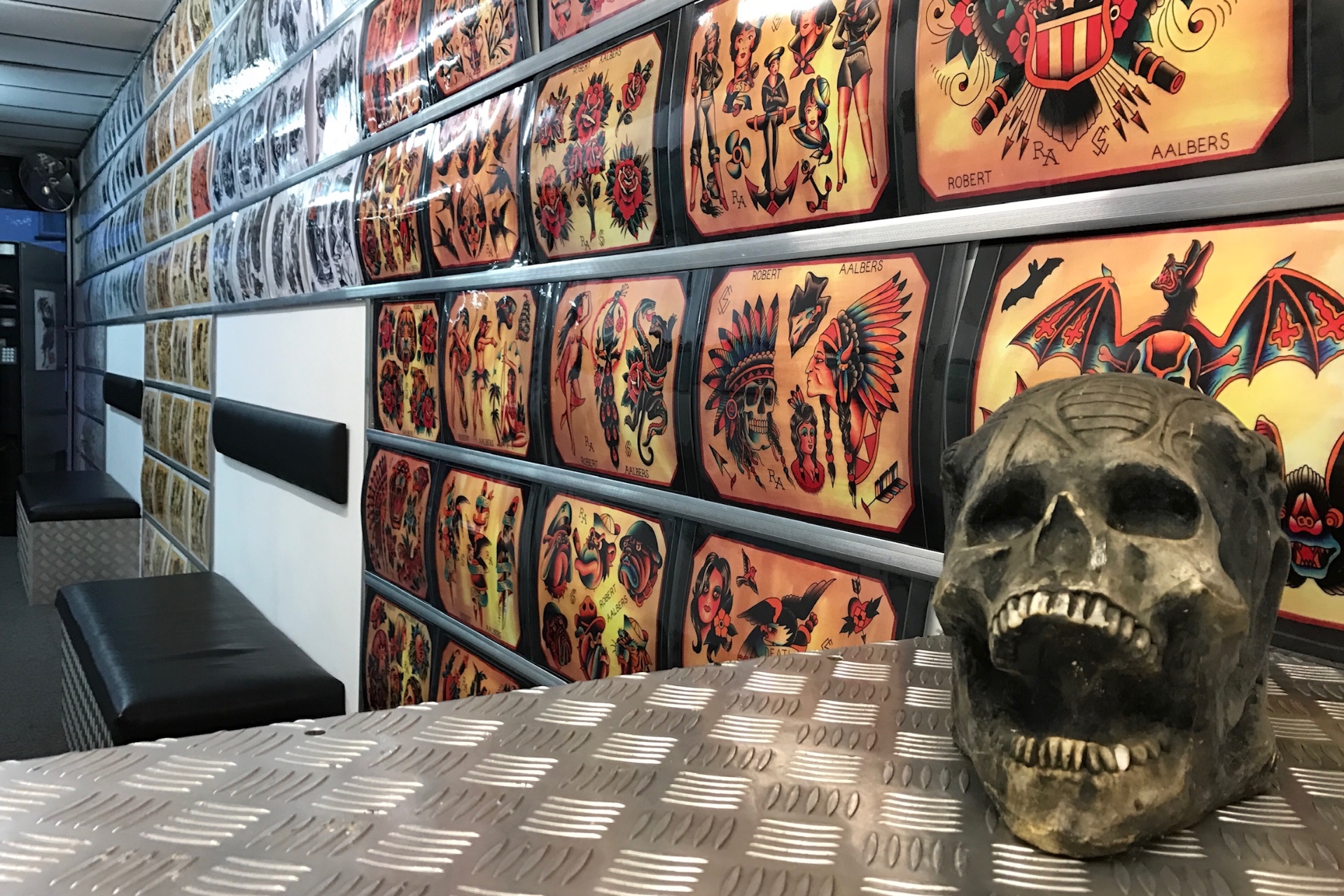 Wall of original tattoo flash sheets in the studio