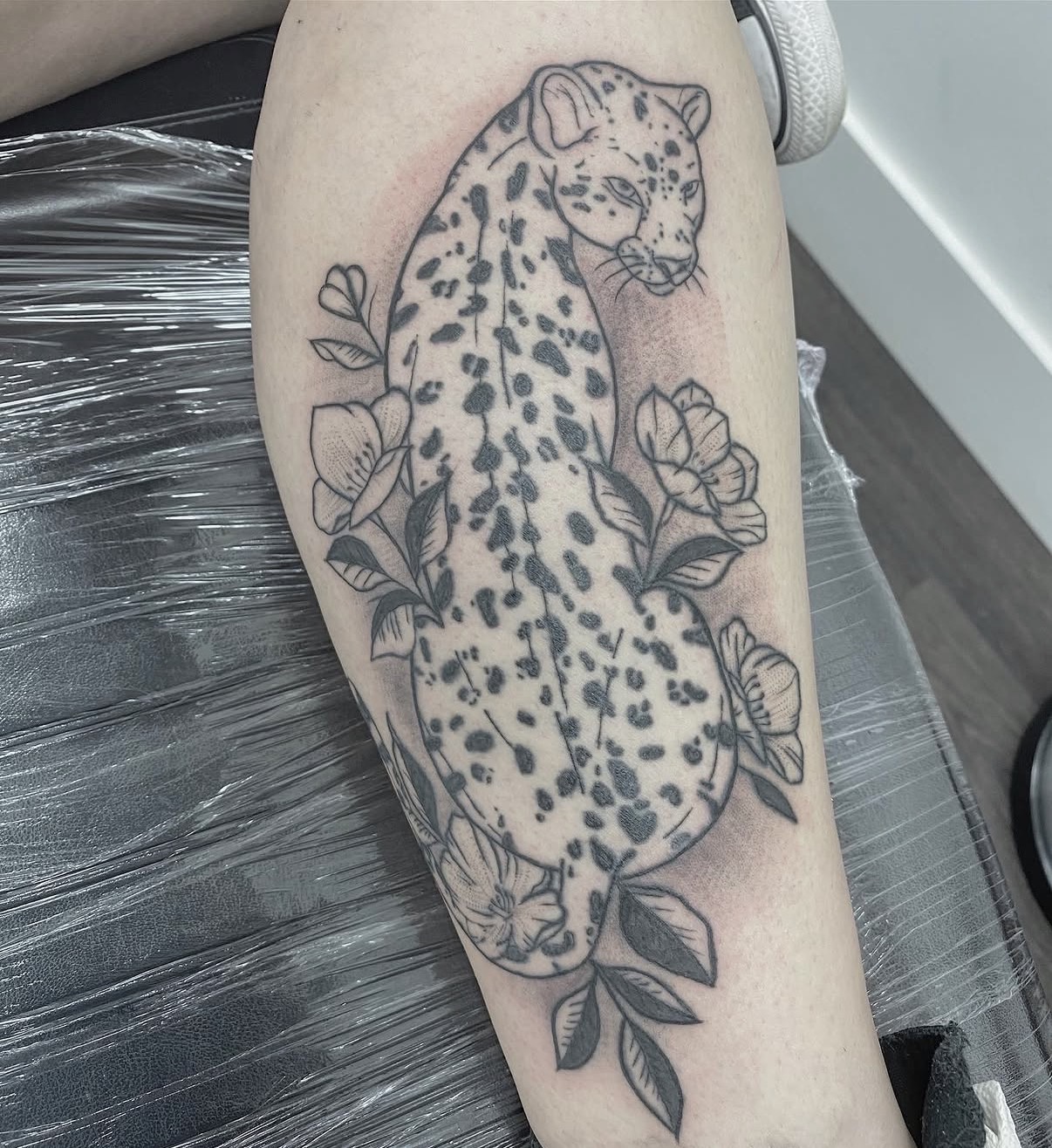 Black and grey leopard with florals tattoo by Clare