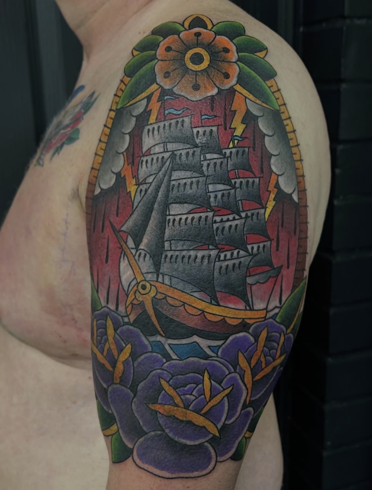 Traditional ship in storm with lightning and purple roses upper arm piece by Danny Birch