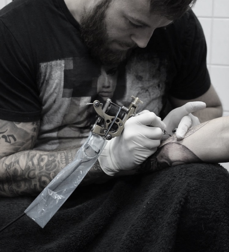 Mantra 2 artist tattooing a client at a private station