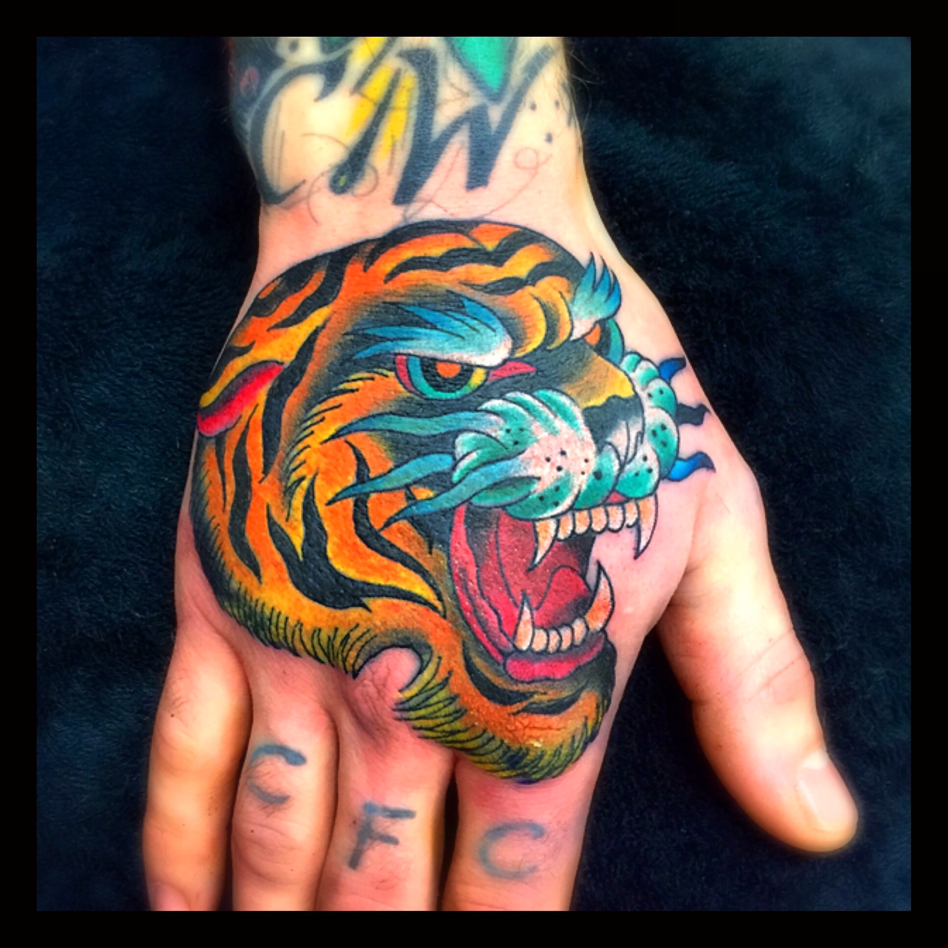 Traditional colour roaring tiger hand tattoo by Steve Evans